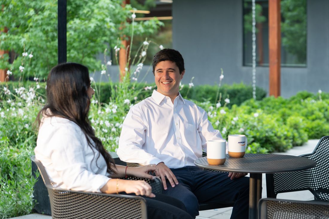 Dos personas conversando en una terraza de la oficina