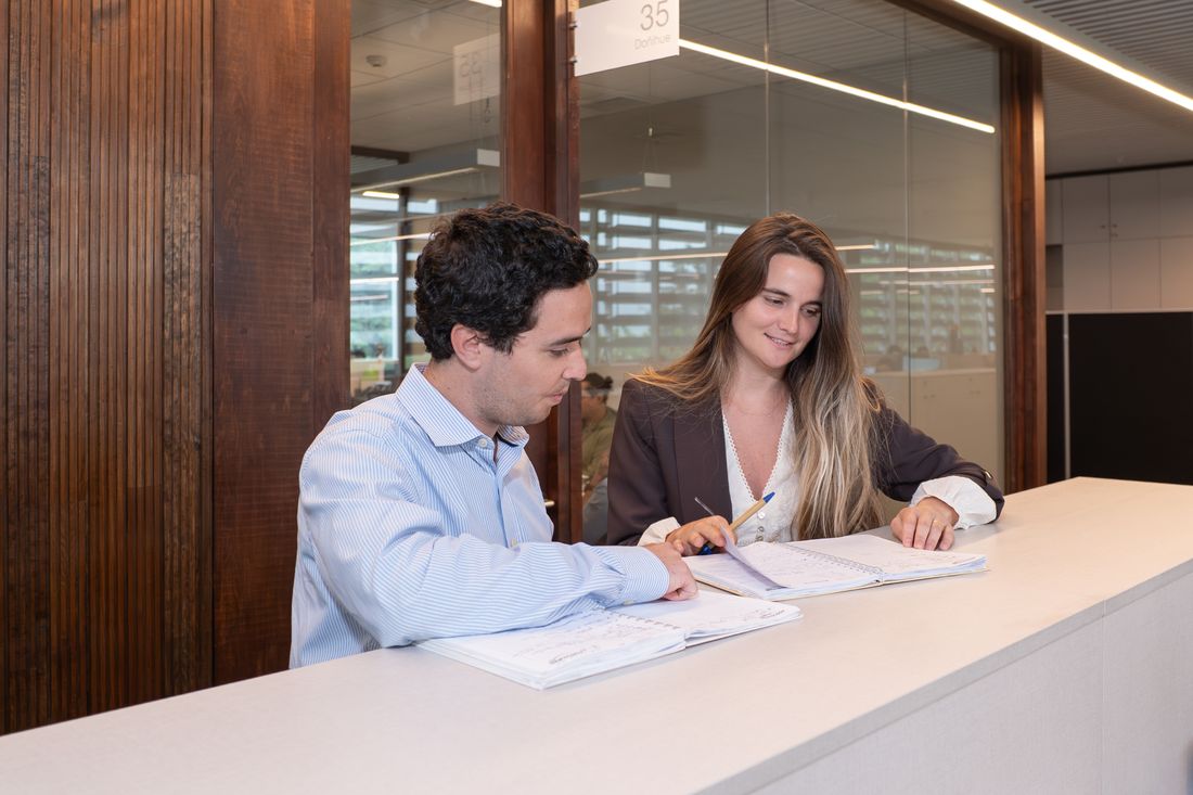 Dos personas revisando documentos en un mesón