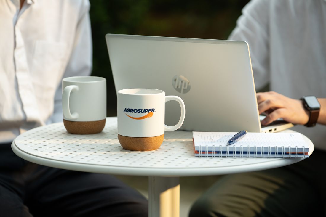 Computador y taza de Agrosuper sobre una mesa
